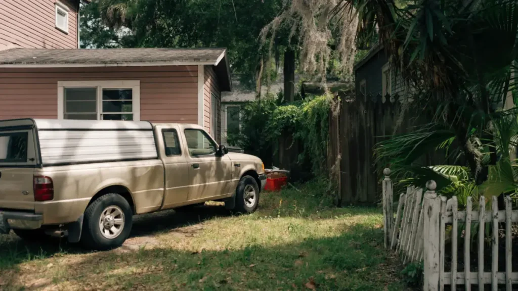 Pickup truck parked at a residential property surrounded by greenery